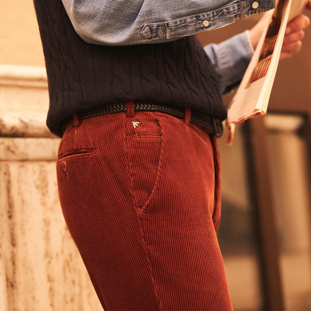 Person wearing red corduroy pants with a blurred background